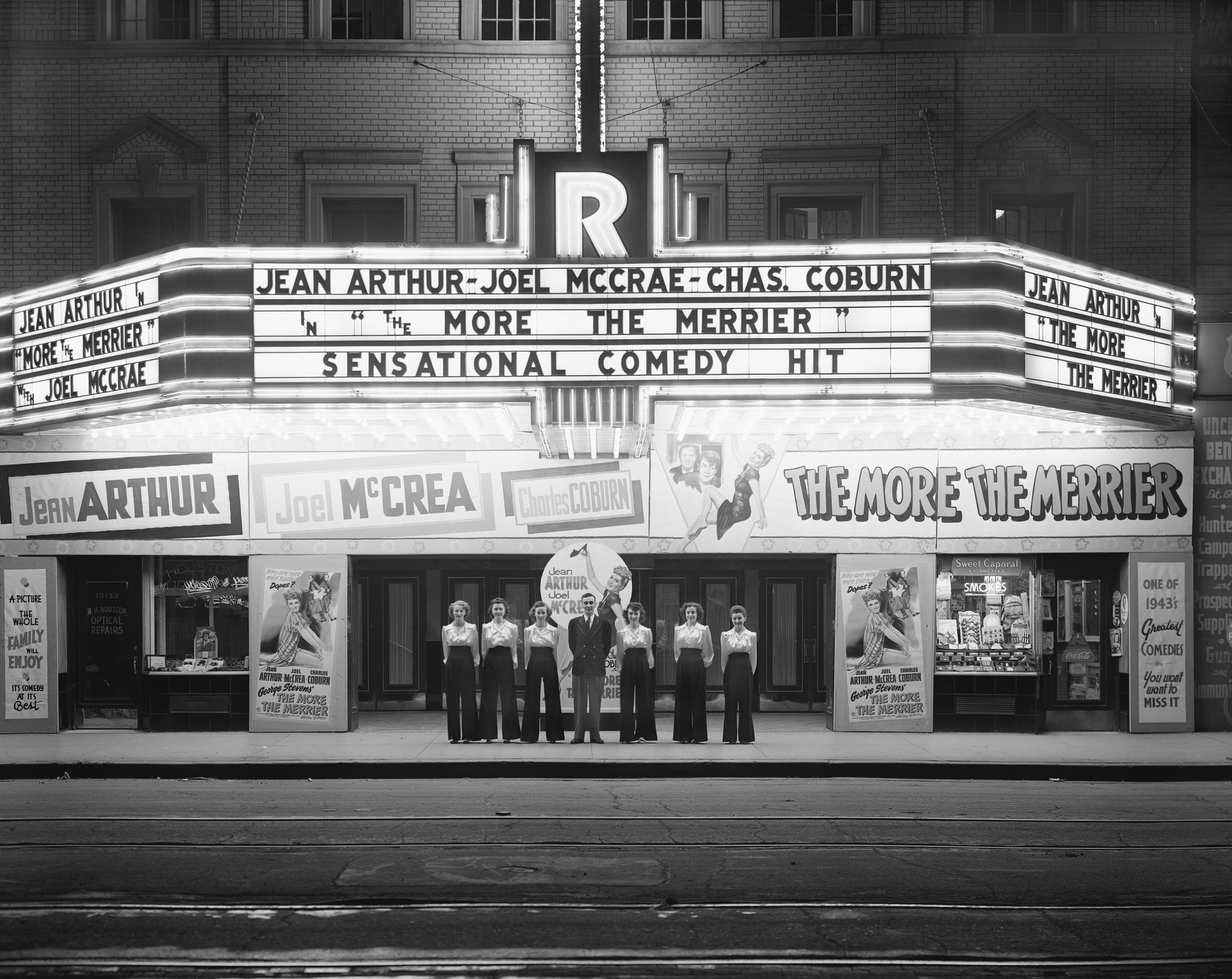 a group of men standing in front of a movie theater