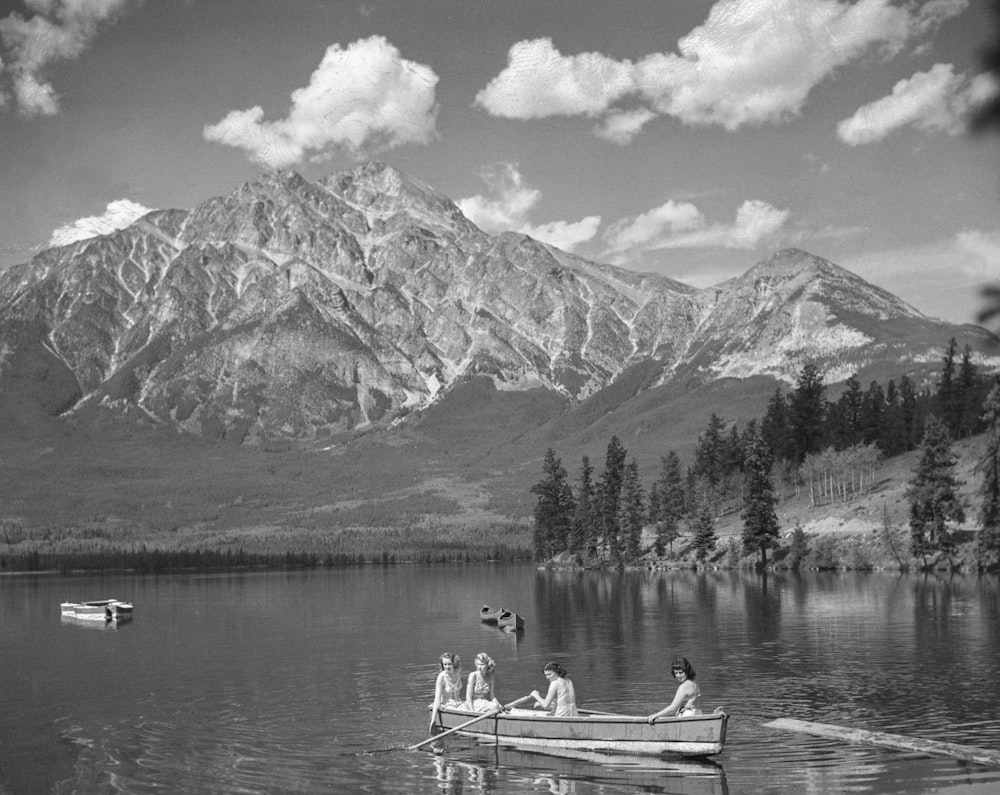 Una foto in bianco e nero di persone in una barca su un lago