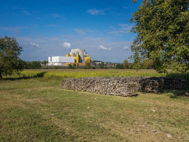 A green farm landscape with a pyrolysis system processing biomass waste in the background under a clear sky.