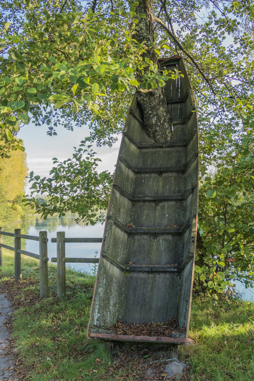 a wooden boat sitting on top of a grass covered field