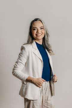 a woman in a white jacket and tan pants