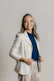 a woman in a white jacket and tan pants