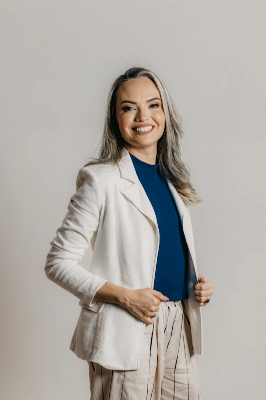 A professional career coach smiling warmly with a modern office background.