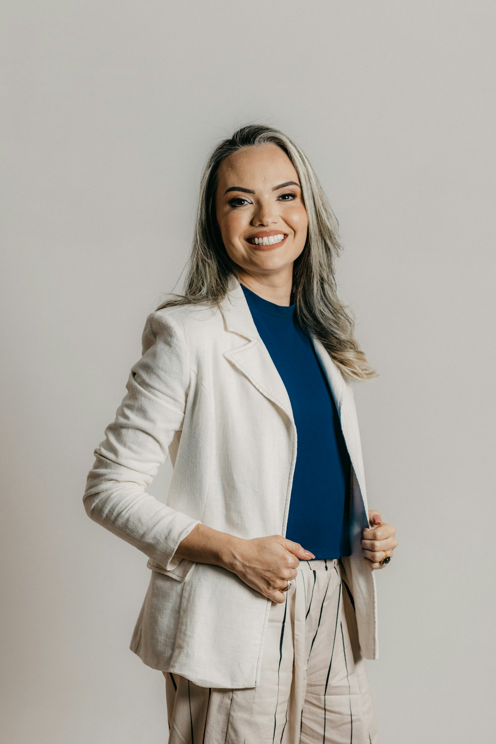 a woman in a white jacket and tan pants