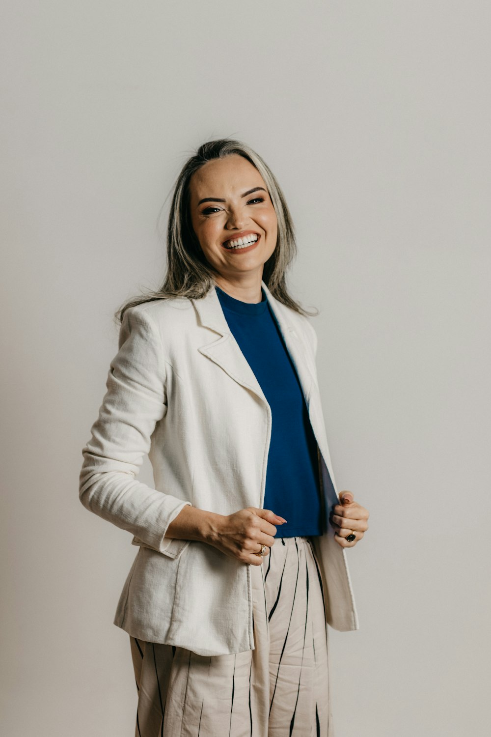 a smiling woman in a white jacket and pants