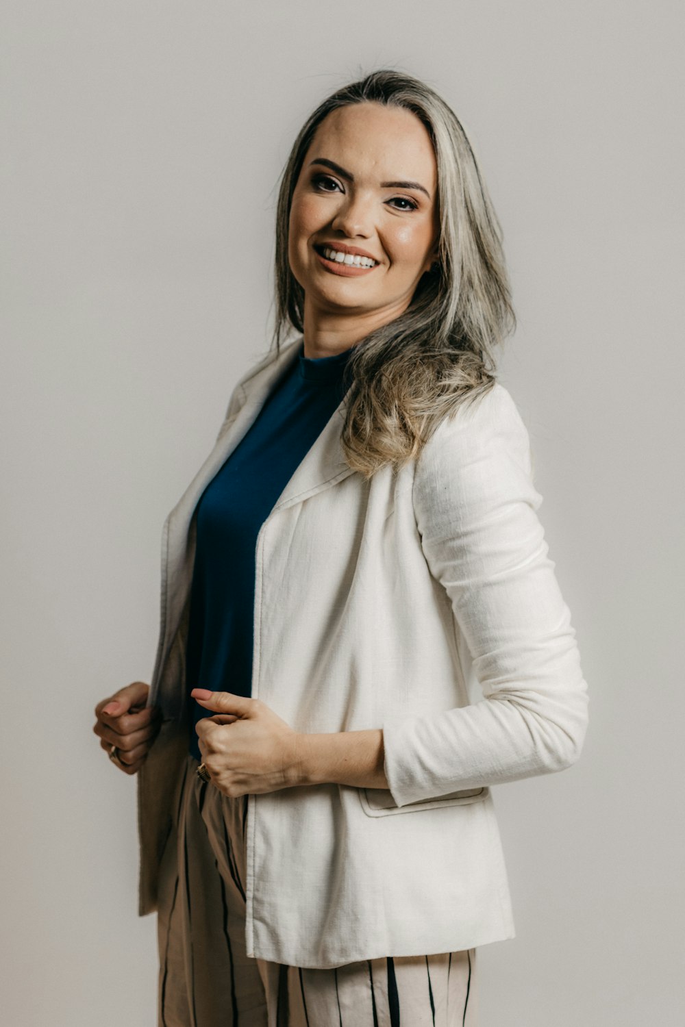 a smiling woman in a white jacket