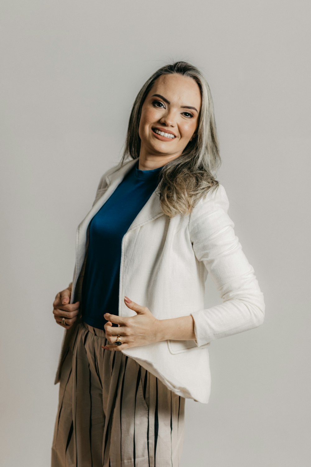 a woman posing for a picture in a white jacket