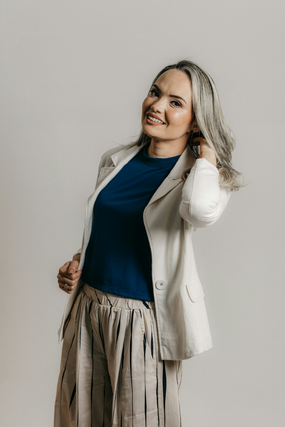 a woman in a white jacket and tan pants