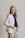 a woman in a white jacket and striped pants