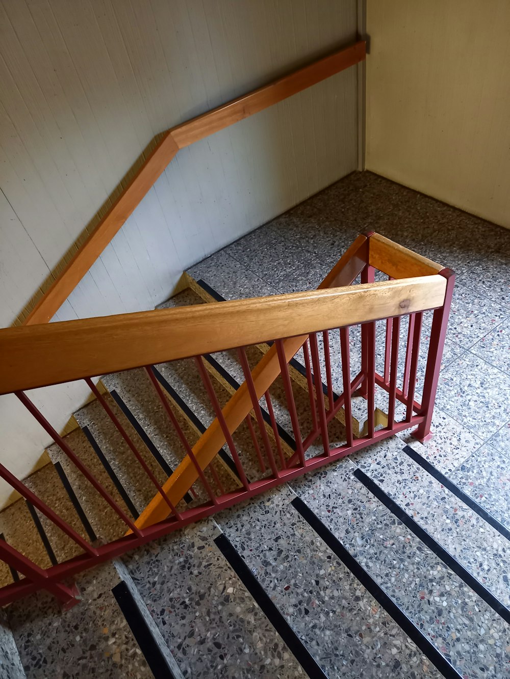 a staircase with a wooden handrail and metal railing