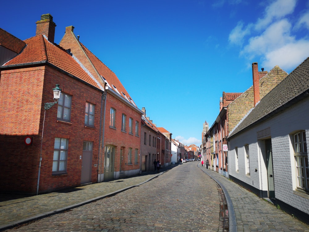 a cobblestone street lined with red brick buildings