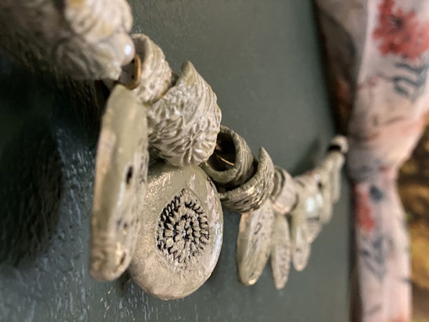 Close-up of intricate metal wall art displayed on a textured wall background.