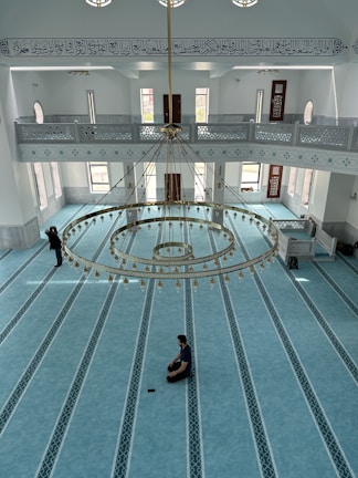 A spacious hotel room featuring a prayer area and large windows overlooking the holy Haram.