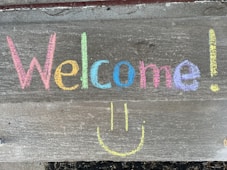 a welcome sign with a smiley face drawn on it