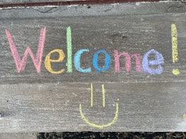 a welcome sign with a smiley face drawn on it