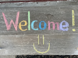 A smiling team member holding a welcome sign.