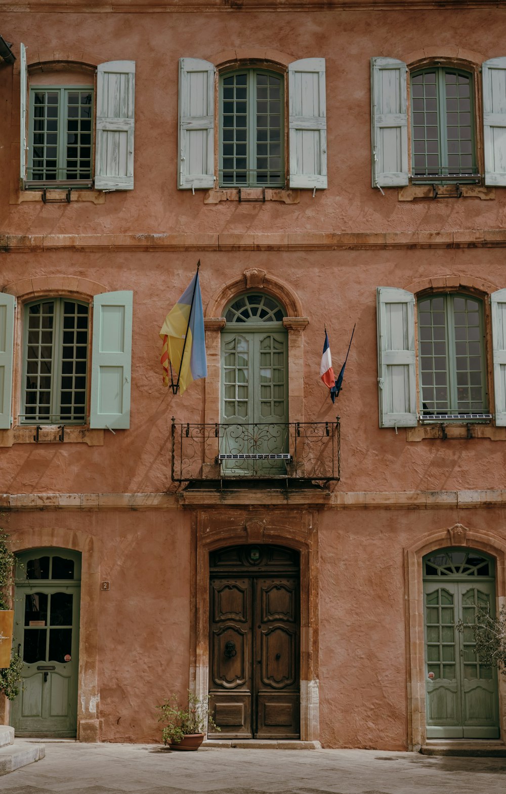 an old building with green doors and shutters