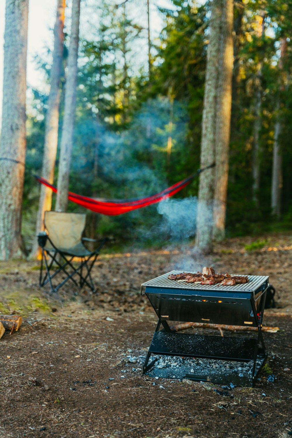 a campfire with a hammock in the background