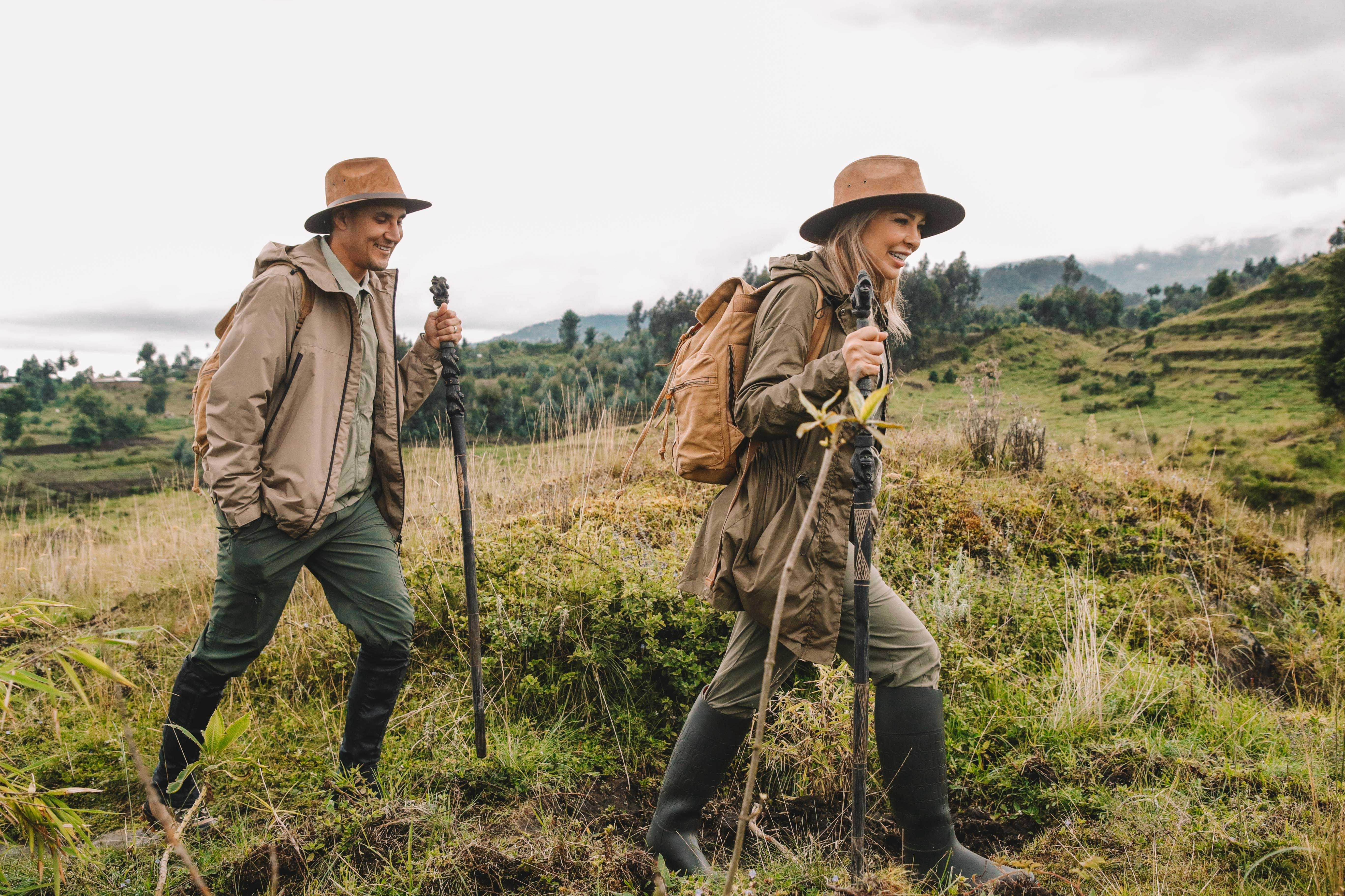 a couple of men walking across a lush green field