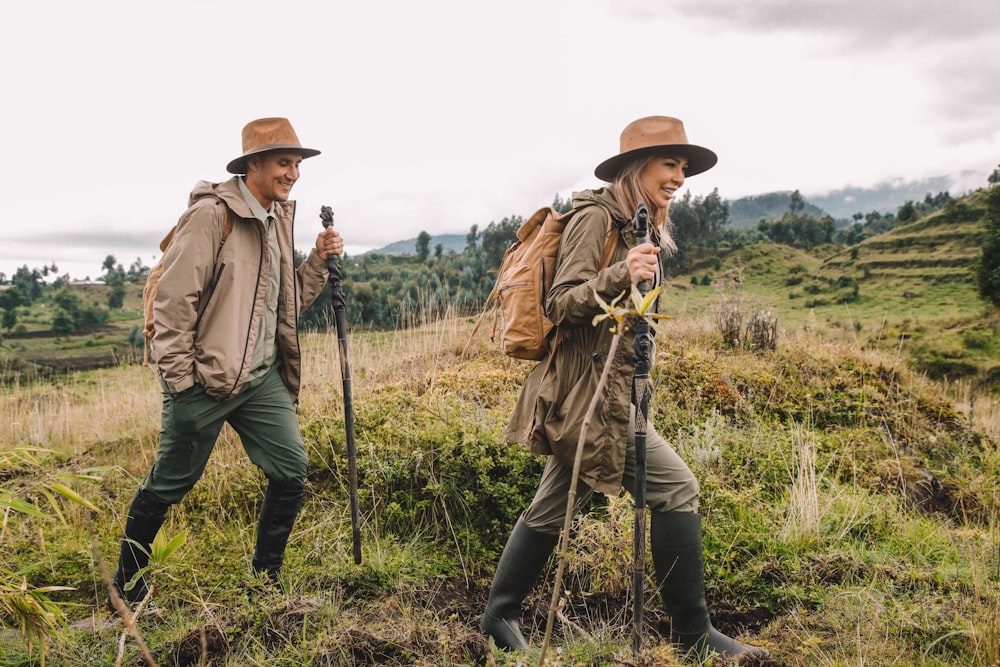 a couple of men walking across a lush green field