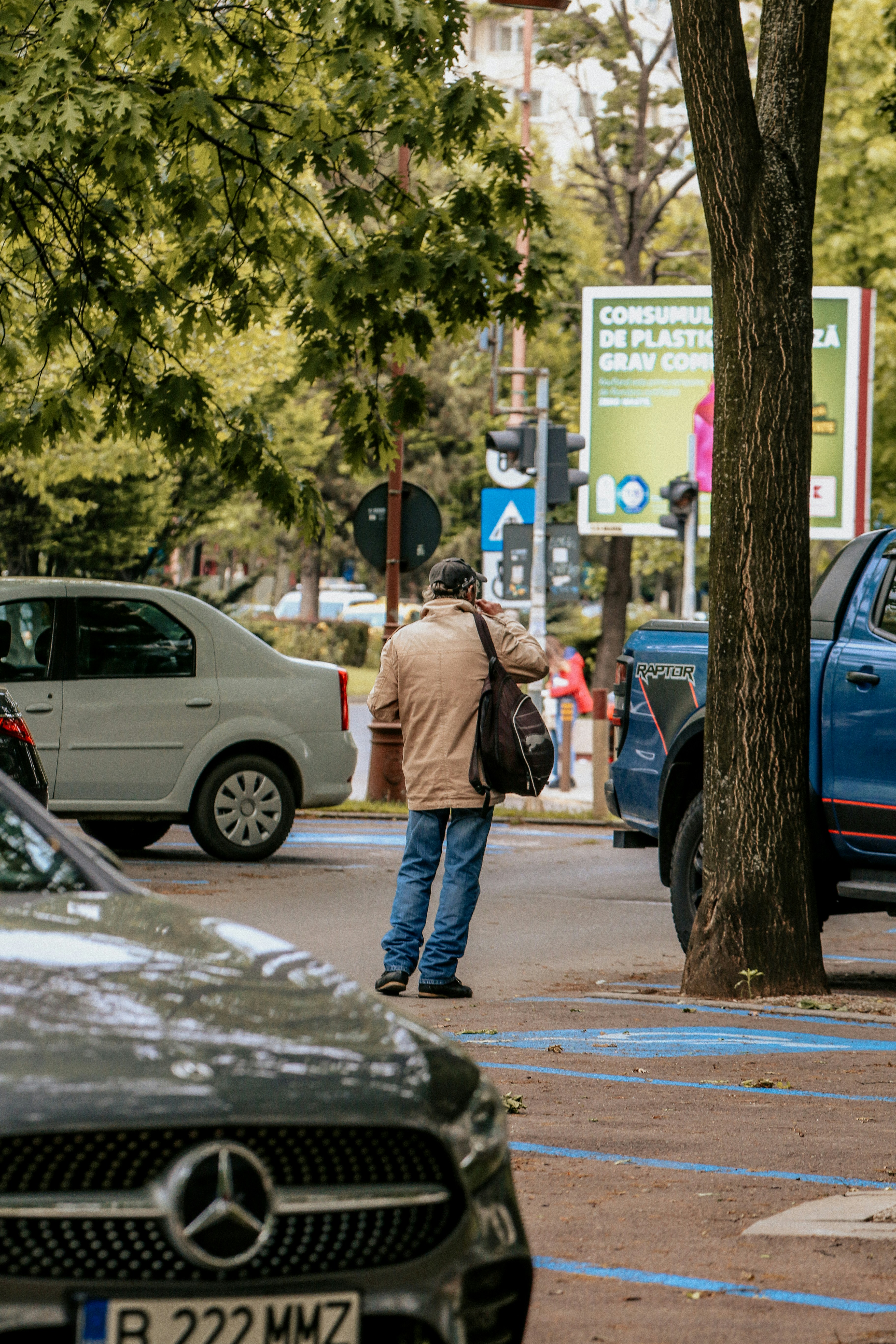 a man standing on the side of a road next to a tree