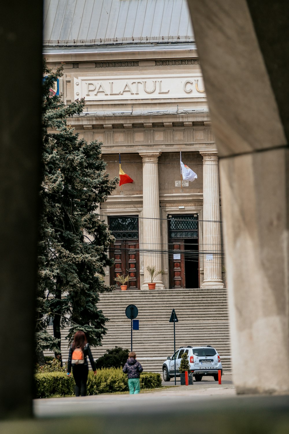 Un par de personas que caminan frente a un edificio