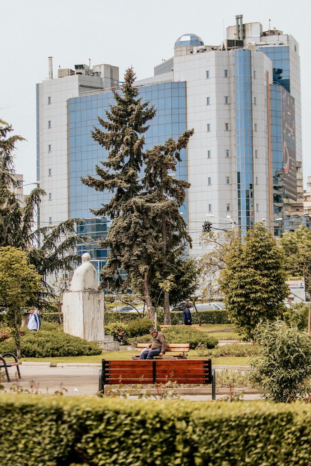 a couple of people sitting on top of a wooden bench