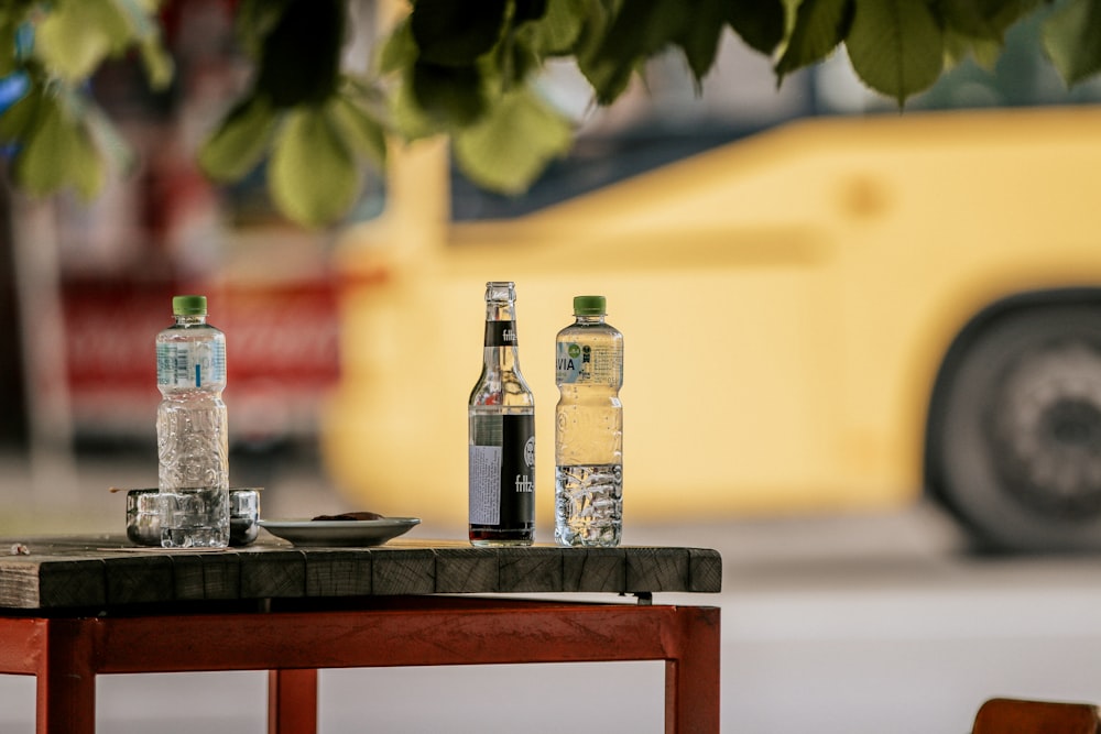 a couple of bottles of water sitting on top of a wooden table