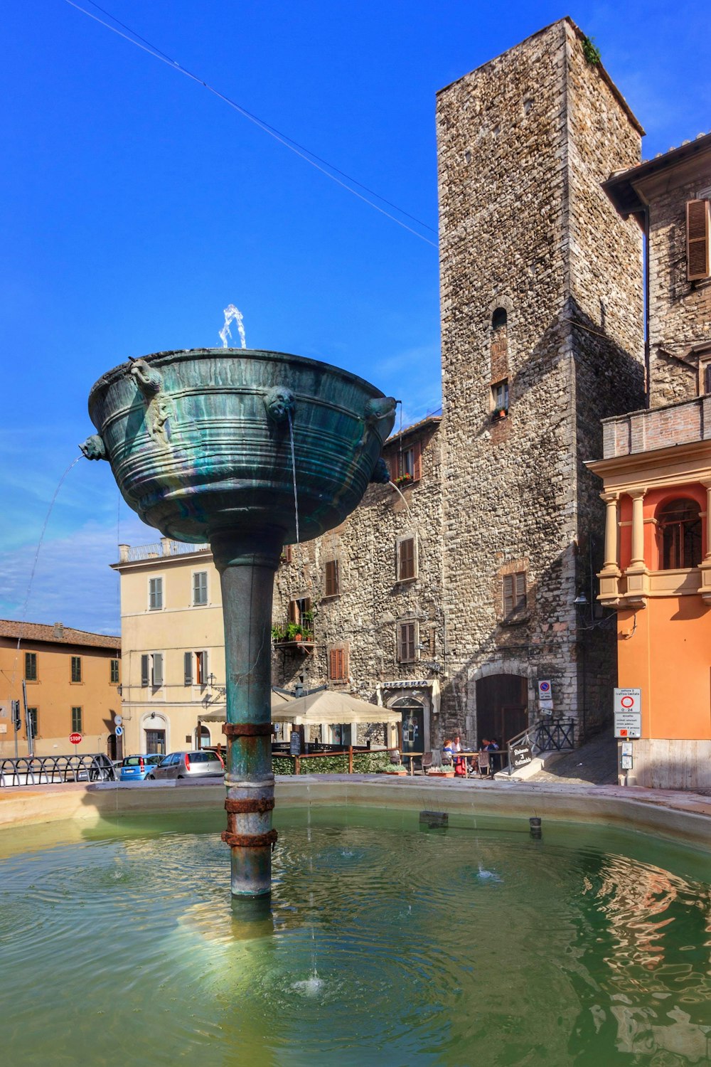 a water fountain in front of a stone building