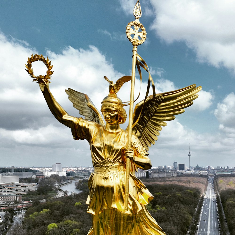 a golden statue of an angel holding a staff