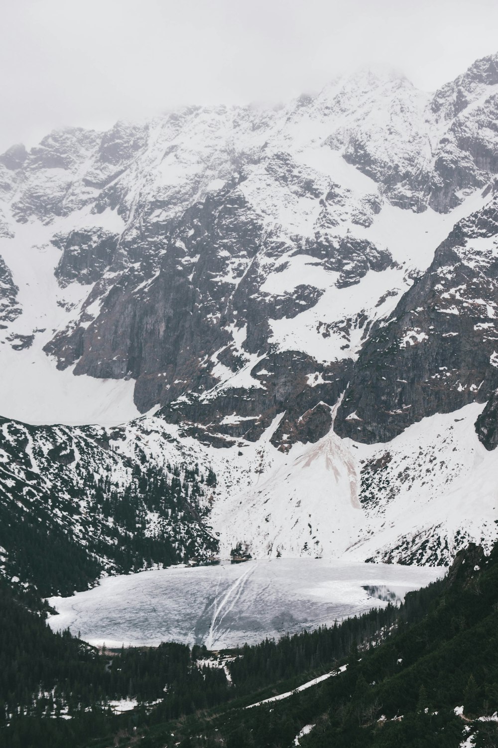 a snow covered mountain with a lake in the middle