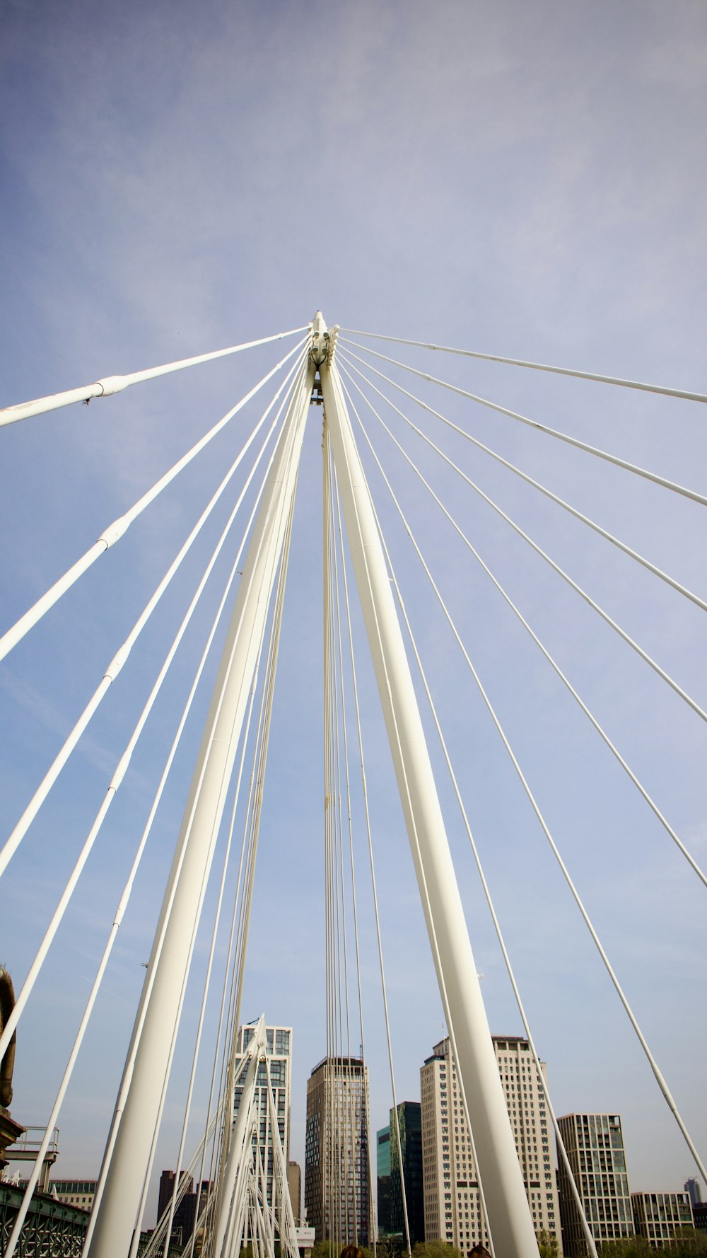 a tall white bridge spanning over a city
