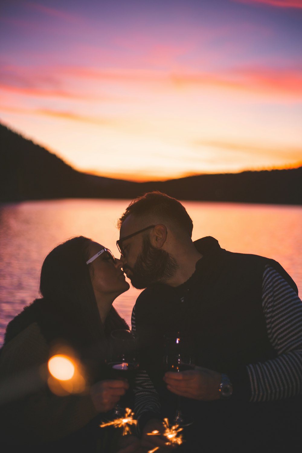 a man and a woman sitting next to each other near a body of water