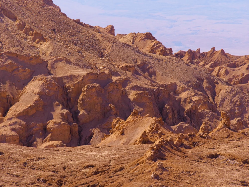 a rocky mountain with a blue sky in the background