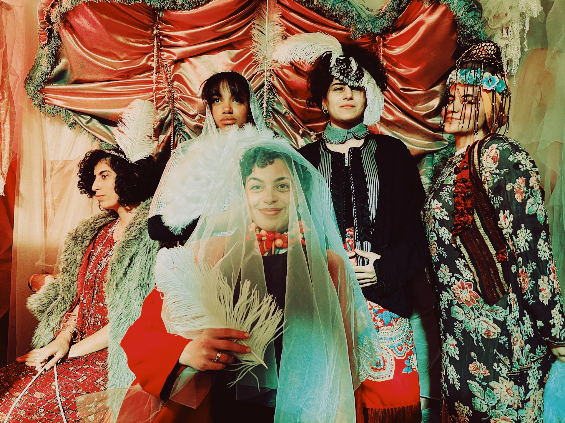 Guests engaged in an immersive murder party event, dressed in themed costumes, interacting with each other in a richly detailed setting.