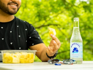 Artisanal foleré ananas bottle with sliced pineapple and green leaves on a wooden table