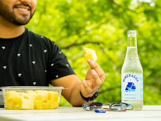 Artisanal foleré ananas bottle with sliced pineapple and green leaves on a wooden table