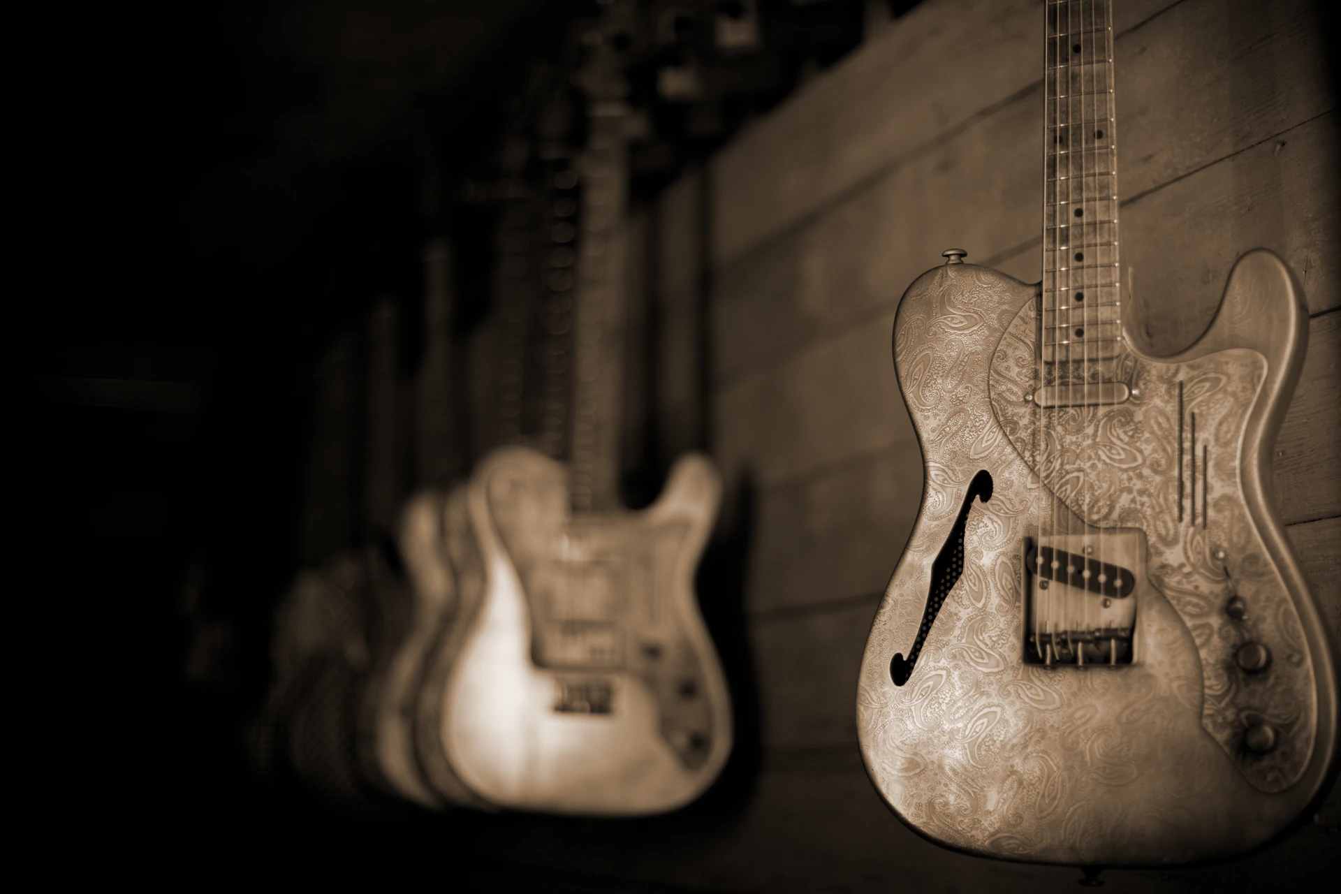 a row of guitars hanging on a wall