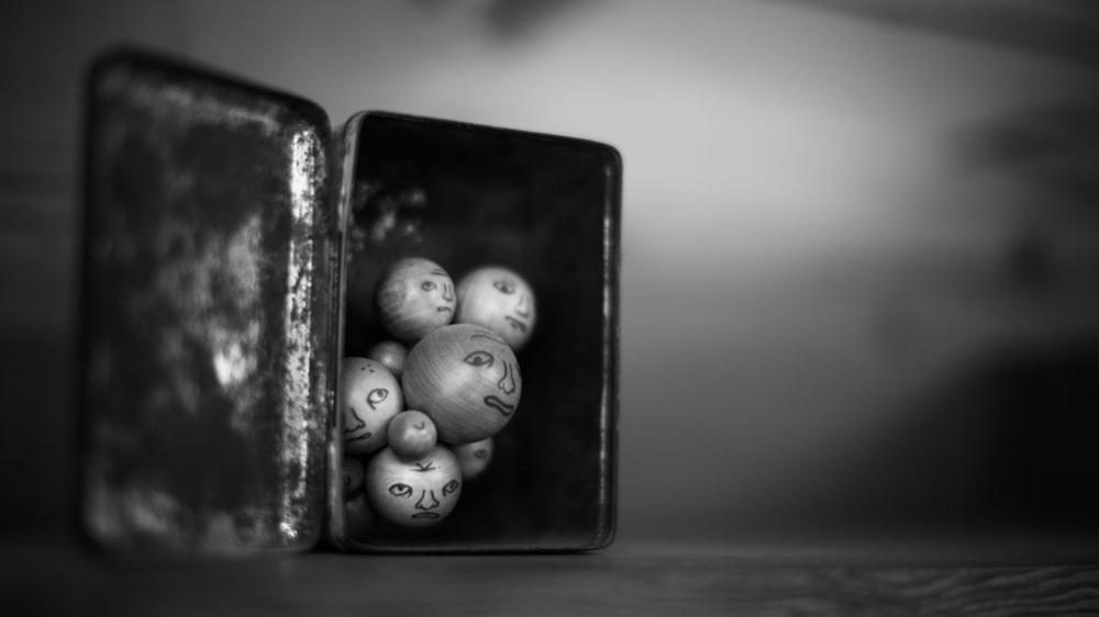 a black and white photo of balls in a box