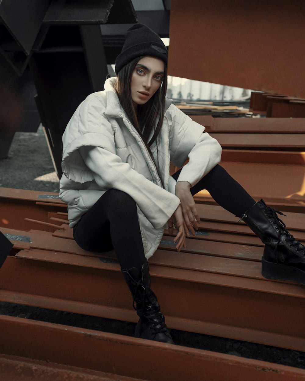 a woman sitting on top of a wooden bench