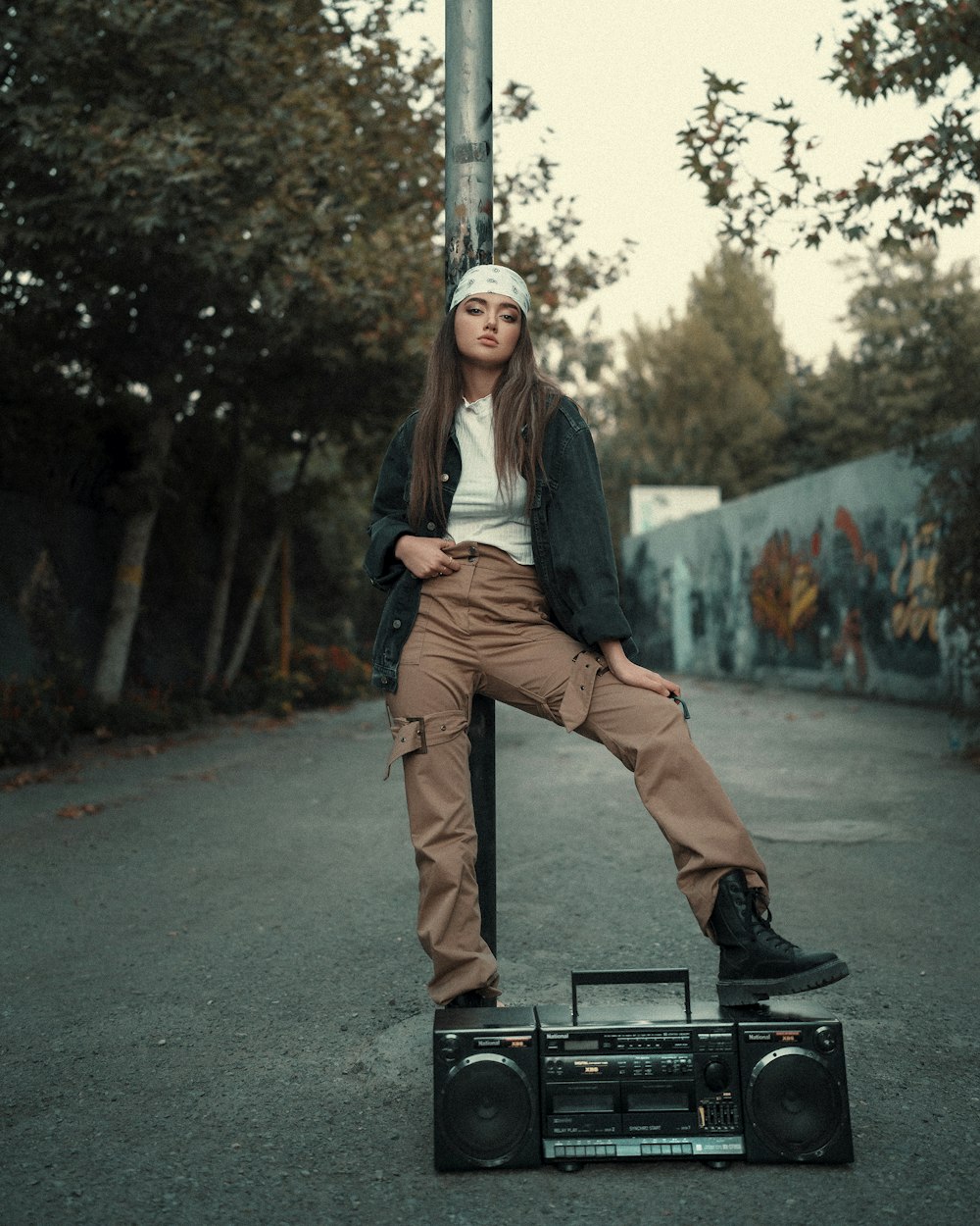 a woman sitting on top of a radio on top of a pole