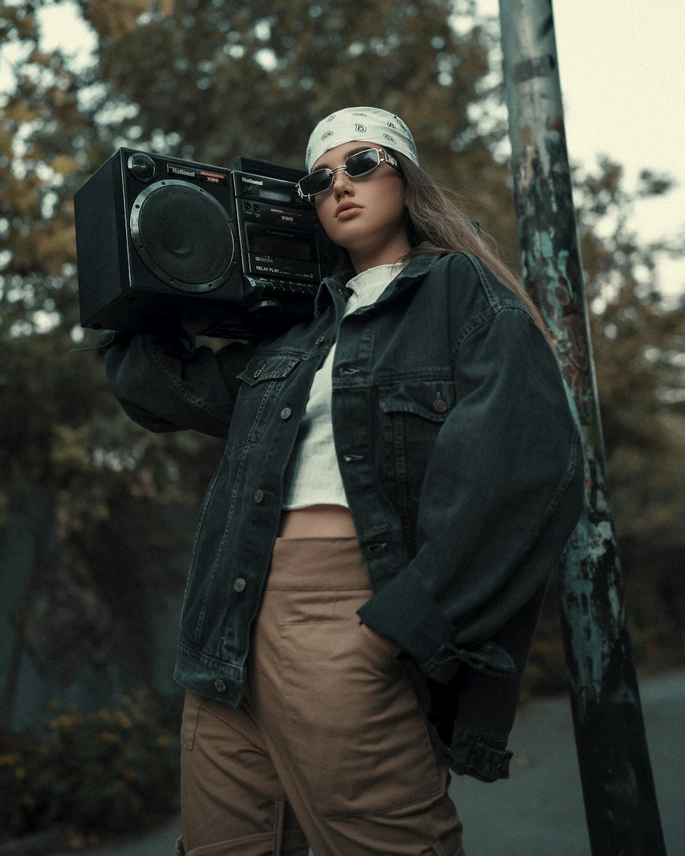 a woman wearing a bandana holding a boombox