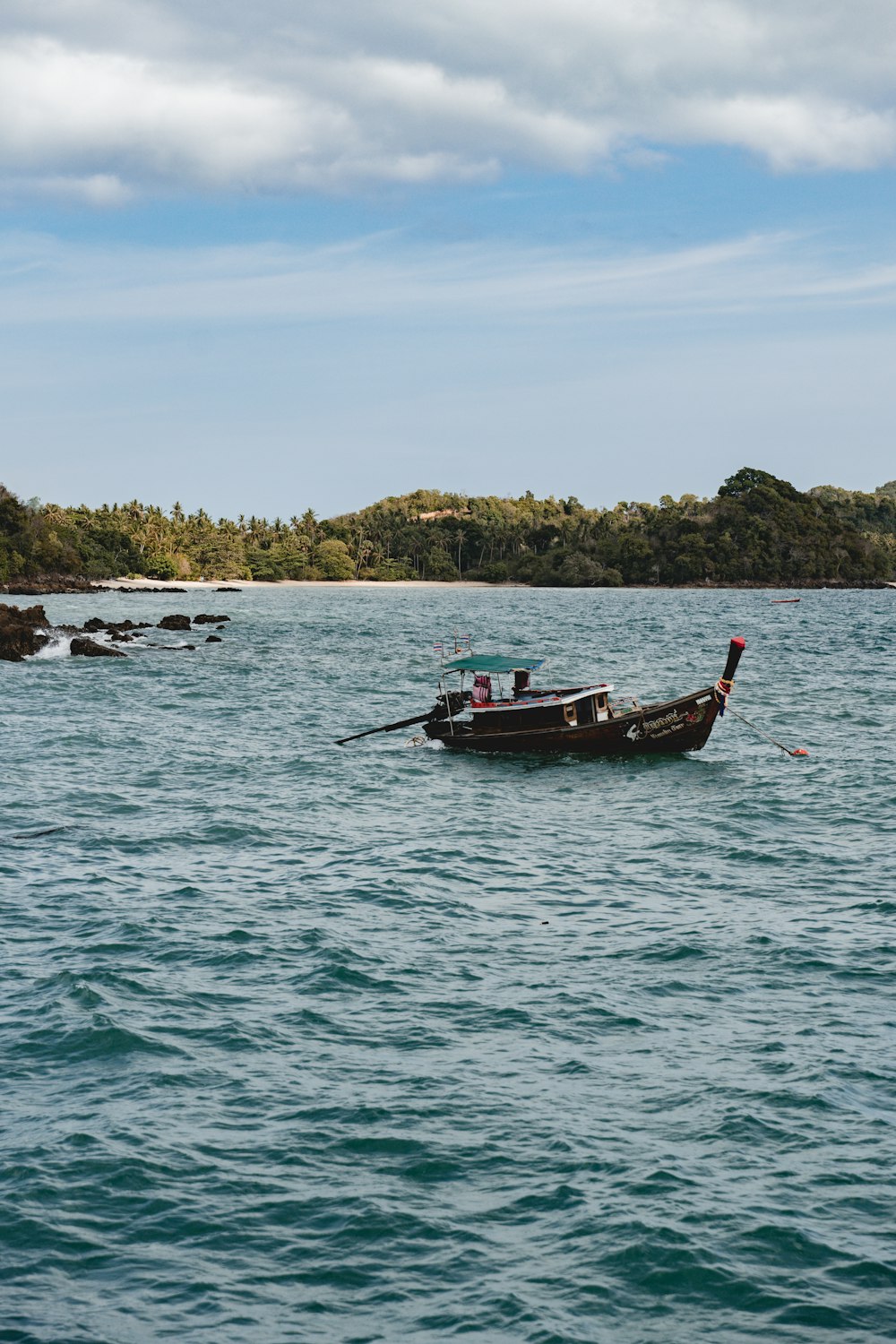 um pequeno barco flutuando em cima de um grande corpo de água