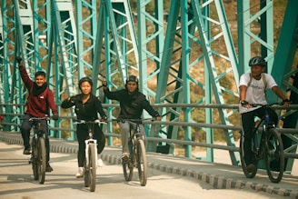 a group of people riding bikes across a bridge