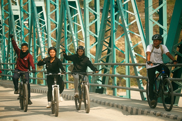 a group of people riding bikes across a bridge