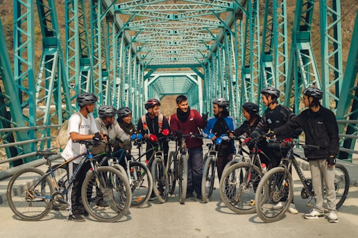 a group of people standing on a bridge with bikes