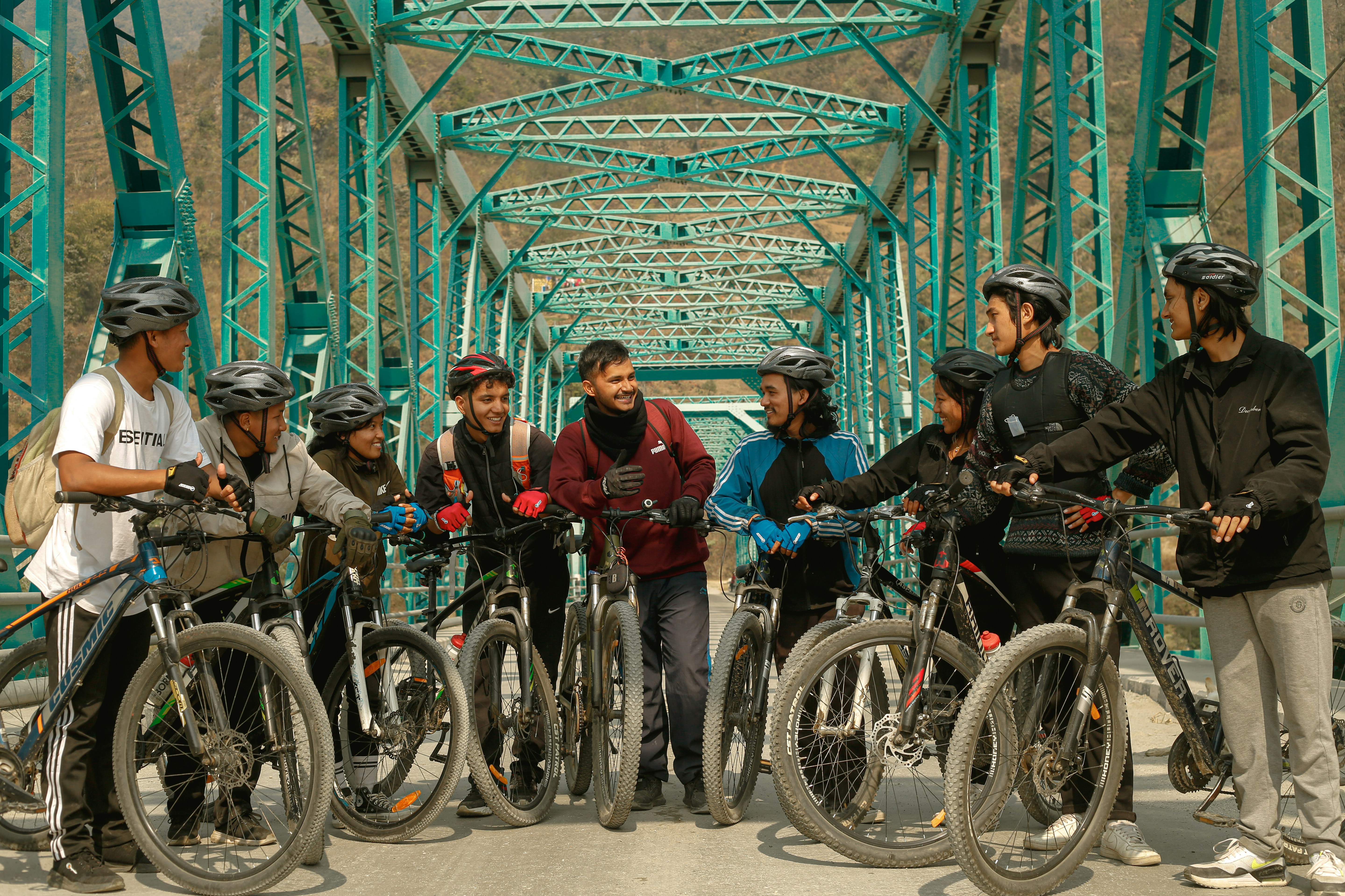 a group of people standing on a bridge with bikes