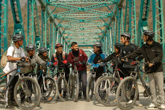 Group of riders and hikers gathered at a trailhead sharing smiles and stories.