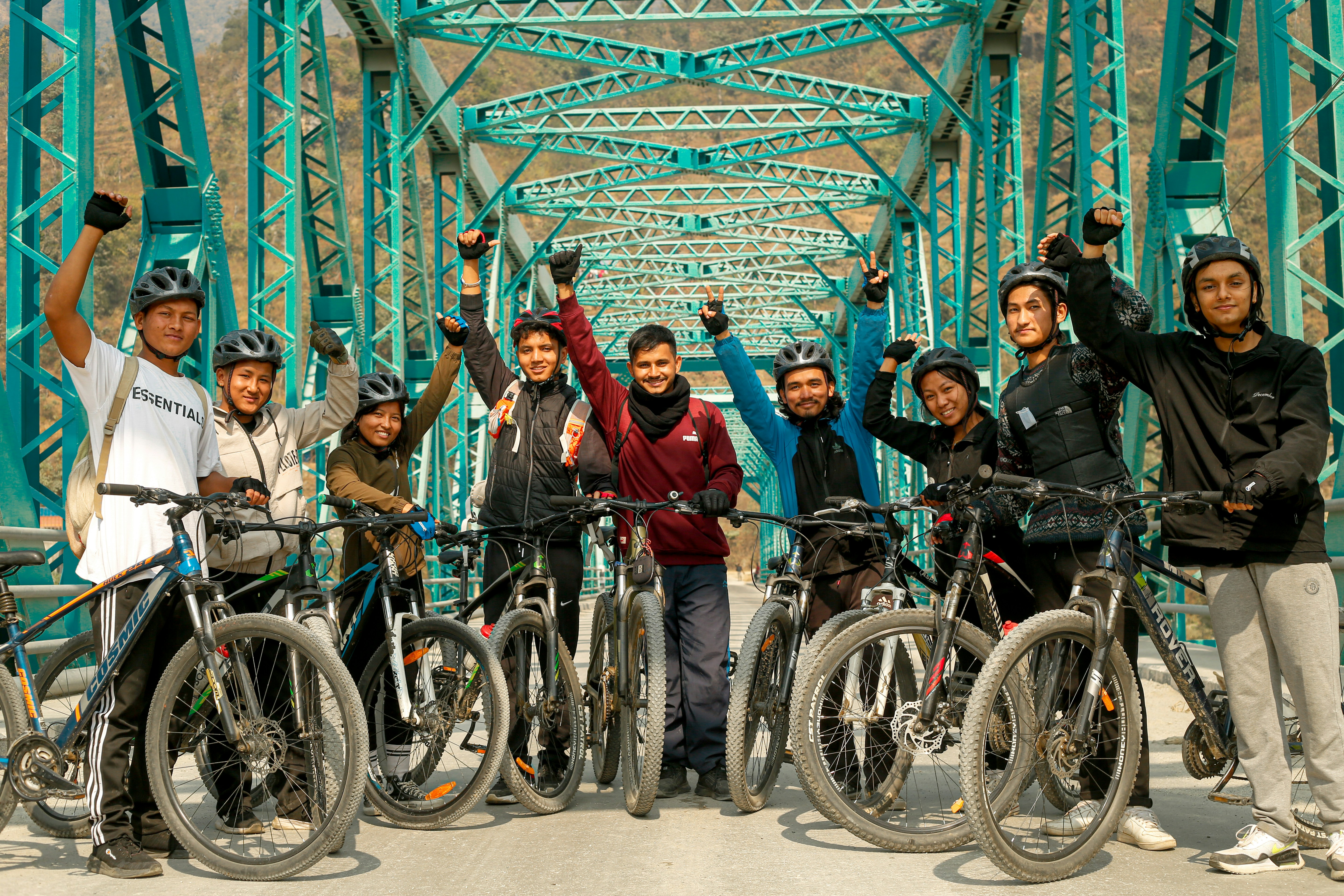 a group of people standing next to bikes on a bridge