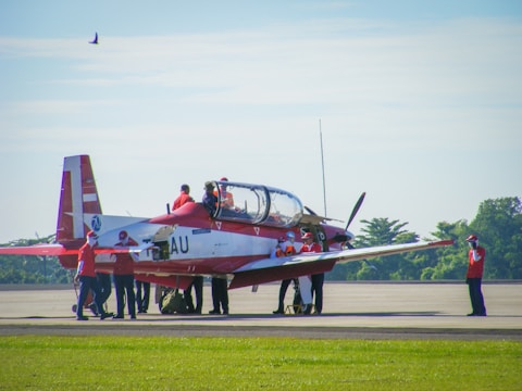 Students gathered around a small plane preparing for a lesson.